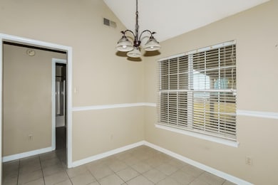 Unfurnished dining area featuring a chandelier, light tile patterned floors, and high vaulted ceiling