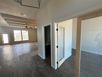 Hall featuring dark wood-style flooring and baseboards