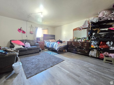 Bedroom with light wood-style flooring and a textured ceiling