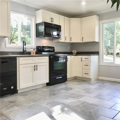 Stunning white cabinets are the highlight of this modern kitchen with both pendant and canister lighting.