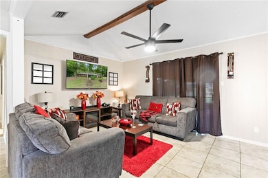 Living room with light tile patterned flooring, a ceiling fan, and wood walls