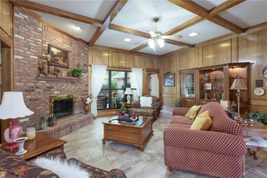 This living area is spacious with wood burning fireplace and view of the backyard.