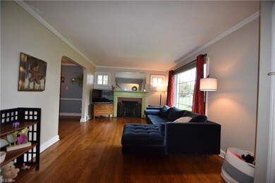 Hardwood floored living room with crown molding an