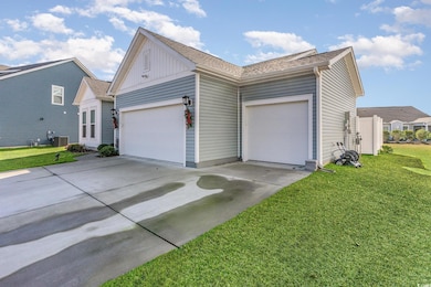 View of side of home featuring driveway, a lawn, an attached garage, and board and batten siding
