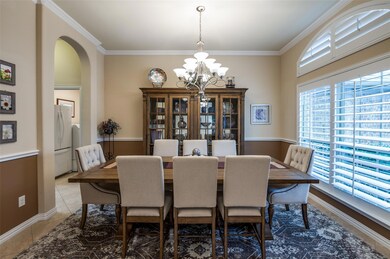 Tiled dining room featuring crown molding and an i