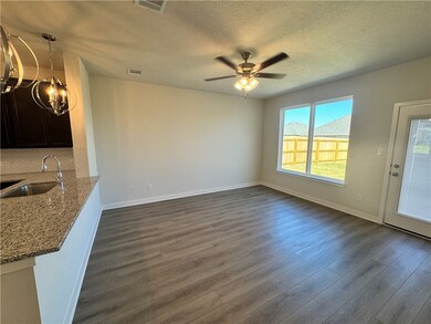 Unfurnished dining area featuring dark wood-type flooring, a textured ceiling, ceiling fan, and a chandelier