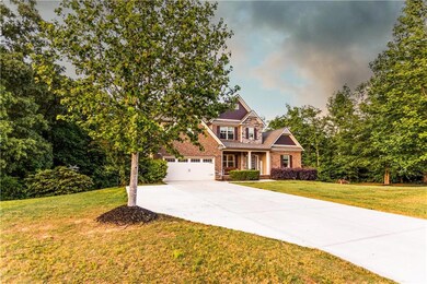 View of front of property featuring a porch, a gar
