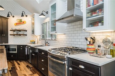 View of range, stainless farm sink, dishwasher and