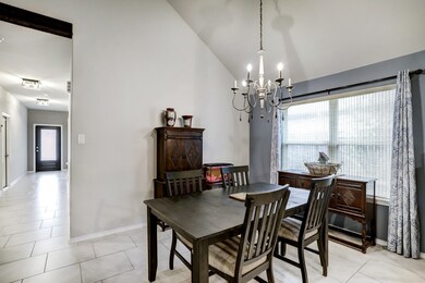 Just off the kitchen is the spacious dining area. A sophisticated chandelier hangs from the soaring ceiling.