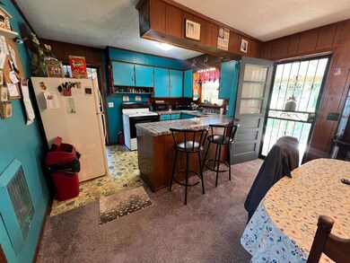 Kitchen featuring white appliances, a textured cei
