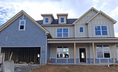 View of front facade featuring board and batten siding and a porch