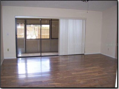 Living Room - Beautiful hardwood floors and a tiled enclosed lanai for effortless entertaining.