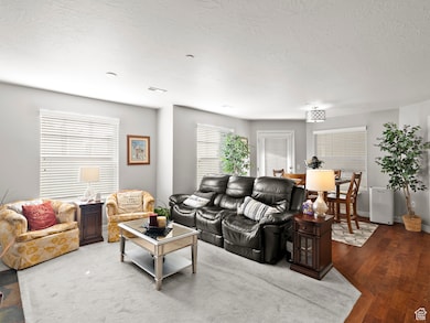 Living room with a textured ceiling and dark wood-type flooring
