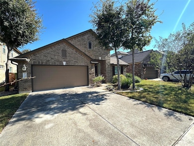 View of front of home featuring brick siding, concrete driveway, an attached garage, and a front lawn