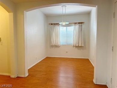 Empty room with wood finished floors, arched walkw
