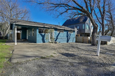 View of front facade featuring a carport and concrete block siding