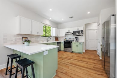 Kitchen featuring visible vents, a peninsula, a b