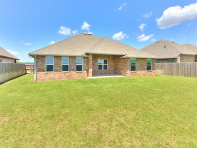 Back of property with a fenced backyard, brick siding, a patio area, and a shingled roof