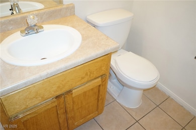 Half bathroom with vanity and light tile patterned flooring
