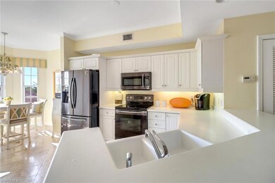 Kitchen featuring a notable chandelier, white cabi