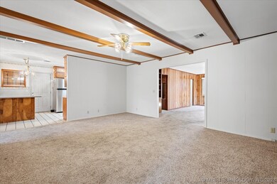 Den with beamed ceiling.