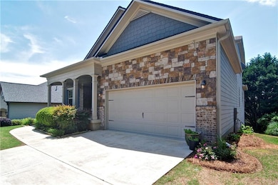 View of front of home with stone siding, driveway,