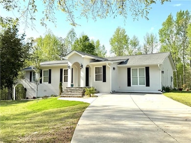Single story home featuring driveway, stucco siding, and a front lawn