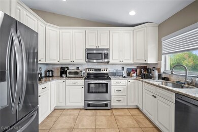 Kitchen featuring stainless steel appliances, backsplash, light stone counters, light tile patterned flooring, and recessed lighting