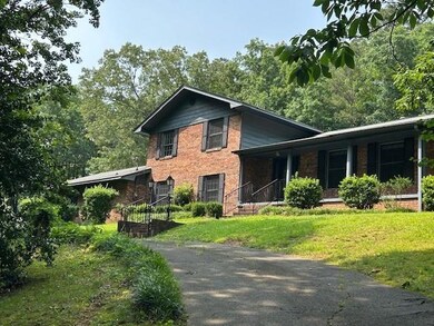 Tri-level home with brick siding, a porch, and a front lawn
