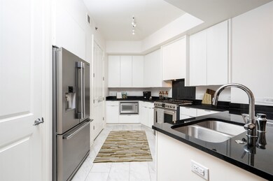 Kitchen with white cabinetry, light tile patterned