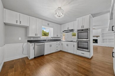 Kitchen featuring a brick fireplace, white cabinet