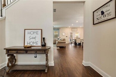 Hall with dark wood finished floors, recessed ligh