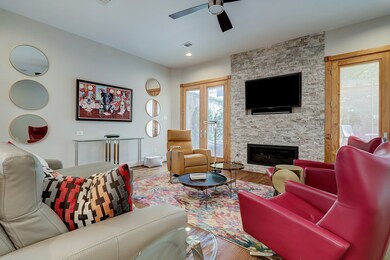 Large first floor living with single light Pella Doors with built in shades - gas glo-light fireplace and recessed tv. Note the high ceilings.
