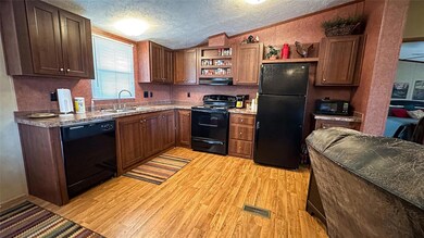 Kitchen with sink, vaulted ceiling, a textured cei