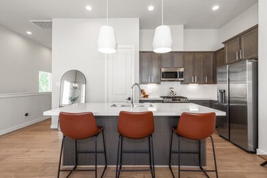 Stylish kitchen featuring quartz countertops, stainless steel appliances, and abundant storage.