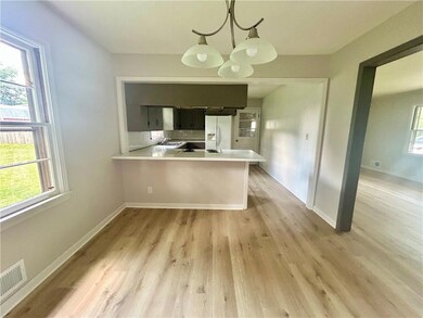 Kitchen with white refrigerator with ice dispenser, light countertops, and plenty of natural light