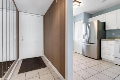 Kitchen with stainless steel refrigerator with ice dispenser, white cabinetry, and light tile patterned floors