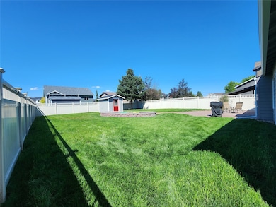 Fenced backyard with a patio area and a storage unit