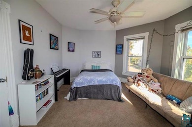 Bedroom with multiple windows, ceiling fan, and ca
