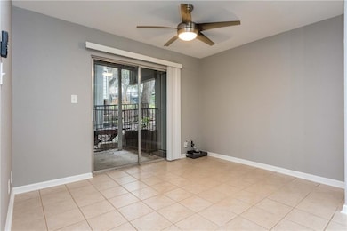 Spare room featuring a ceiling fan and light tile
