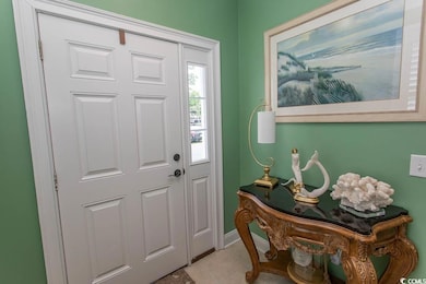 Foyer entrance with light tile patterned floors and baseboards