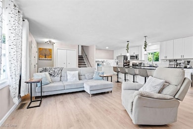 Living area featuring light wood-type flooring and stairs