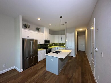 Kitchen featuring sink, an island with sink, white