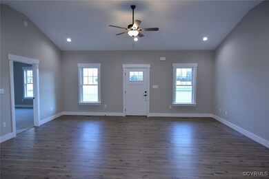 Foyer with ceiling fan, vaulted ceiling, and dark