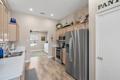 This galley kitchen has stainless appliances. Walk in pantry.