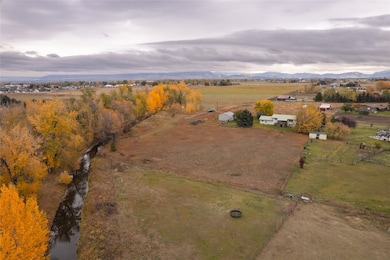Aerial view of property and surrounding area featuring rural landscape and a mountainous background