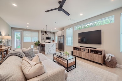Living room with baseboards, ceiling fan, visible