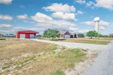 View of yard with an outbuilding, a garage, and driveway