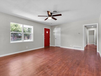 Living room with ceiling fan, a textured ceiling, 