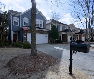 View of front of house featuring concrete driveway, an attached garage, and stone siding